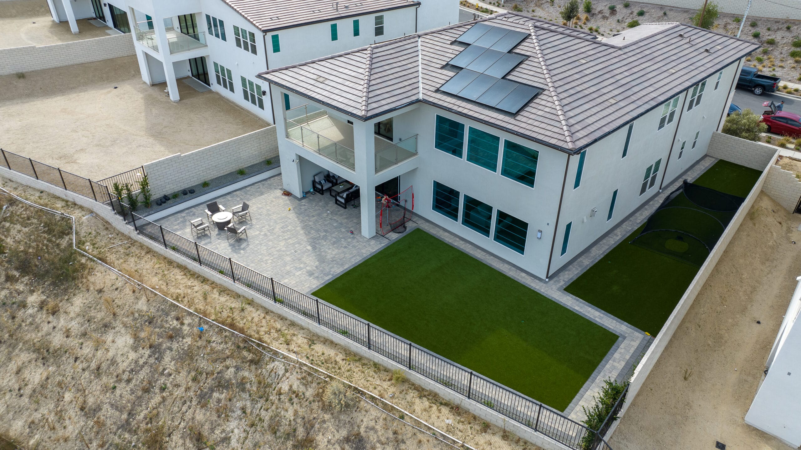 Aerial drone view of a Santa Clarita solar-powered estate with a side artificial turf install